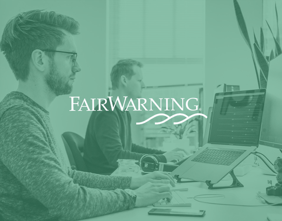 A green overlay with the organization and RadarFirst partner, FairWarning, hovers over a team of information technology professionals who are hard at work at their desktop computers. | RadarFirst