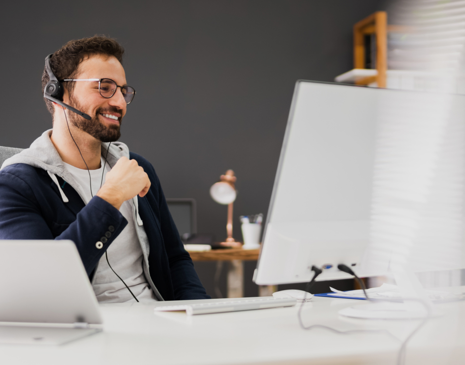 RadarFirst Privacy Incident Management Platform | A young professional in casual garb is engaging in a virtual meeting through use of a headset microphone. They smile in satisfaction as if the meeting's subject is amicable in nature.