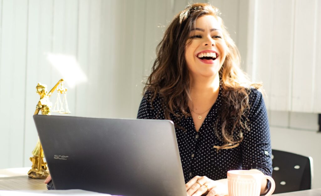 RadarFirst Privacy Incident Management | This image depicts a young person sitting at a laptop, expressing a smile and comfort, presumedly, their personal information is in safe hands.